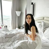 吴雨霏疑似裸身坐在床上，胸前只用被单遮蔽，望向镜头极诱人。