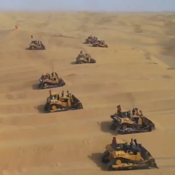 场面震撼！沙漠修公路，30余辆推土机流动沙丘间纵横往返