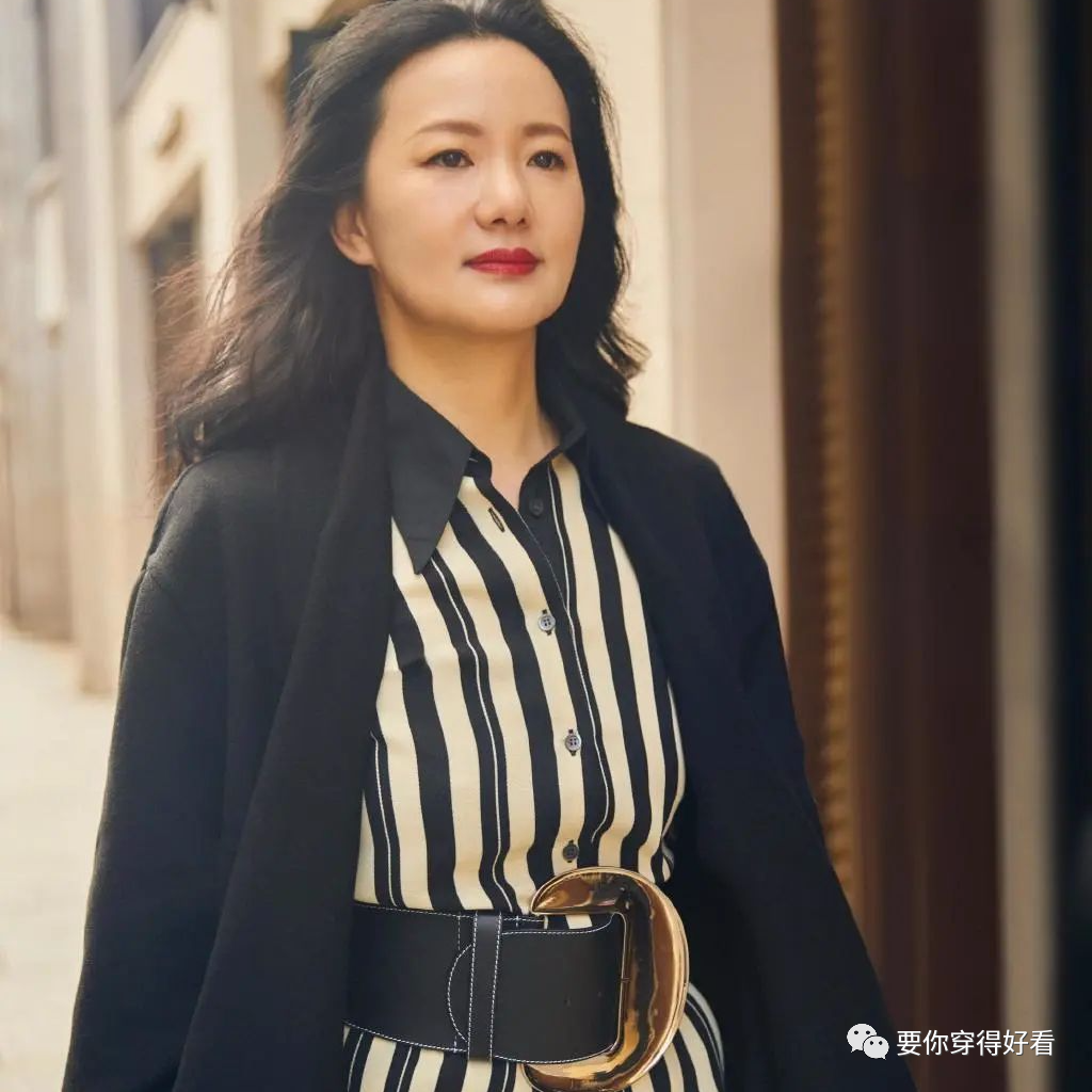 她是中国内地第一位柏林影后，今穿黑色大衣配条纹裙，大气淡雅